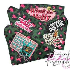 May include: Green and pink leopard print dog bandanas with various embroidered patches. Patches include phrases like "What the Helly", "On my worst behavior", and "Sometimes you have to let your wiener hang out".