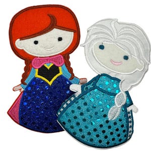 May include: Two embroidered patches featuring cartoon characters. One has red hair, a pink bow, and a blue dress with sequins. The other has white hair and a turquoise dress with sequins. Both have smiling faces.