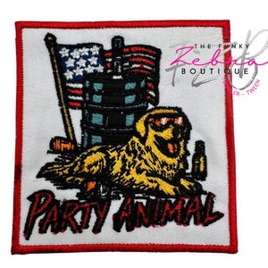 May include: Embroidered patch with a red border featuring a yellow dog wearing sunglasses, a barrel, and an American flag. The text "PARTY ANIMAL" is in red and black. The Funky Zebuta Boutique logo is in the upper right corner.