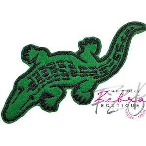 May include: Green embroidered alligator patch with black detailing. The alligator has text embroidered on its back. The Funky Zebra Boutique logo is in the bottom right corner. The patch is for toddler and tween.