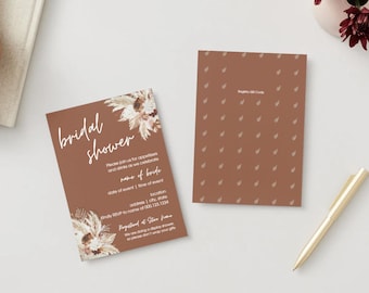 May include: Two brown bridal shower invitations with floral accents and white text. One invitation displays the text "bridal shower" and event details. The other has a pattern and a registry QR code. A gold pen rests nearby.