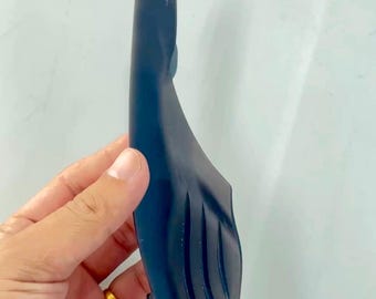 May include: A dark blue, elongated, curved plastic component featuring a tapered end and three parallel, recessed diagonal grooves along its wider section. The object has a smooth, matte finish and a distinct, contoured shape designed for specific assembly.