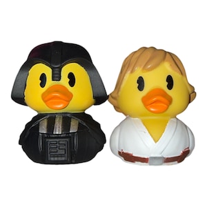 Puede incluir: Dos patitos de goma, uno con el estilo de Darth Vader en negro, el otro como Luke Skywalker en blanco. Ambos patitos tienen cuerpos amarillos, picos naranjas y ojos negros. Un artículo divertido y novedoso para los fans de la franquicia Star Wars.