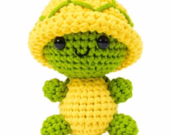 May include: A handmade crochet turtle plushie in yellow and green. The turtle has a yellow shell with green accents, a green head and limbs, and black safety eyes. The turtle is smiling and has a cute, friendly appearance.