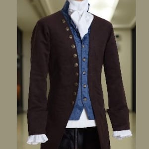 May include: A dark brown, long-sleeved coat with gold buttons, layered over a blue vest and white shirt. The coat has a classic, historical design, with a high collar and long, tailored fit. The sleeves have white ruffled cuffs.