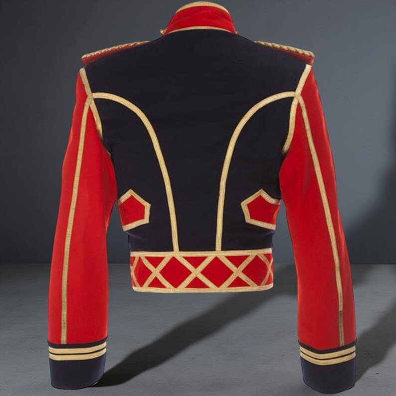 Peut inclure: Veste courte de style militaire, dos noir et manches rouges. Des bordures dor&eacute;es soulignent le design, notamment le col, les &eacute;paules et les motifs g&eacute;om&eacute;triques &agrave; la taille. Les manches ont des rayures dor&eacute;es pr&egrave;s des poignets. Un v&ecirc;tement saisissant.