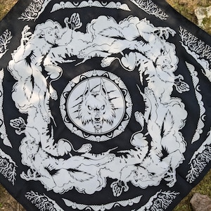 May include: Black bandana with a white repeating pattern of wolves howling at the moon. The center of the bandana features a large wolf head with a skull and crossbones design.
