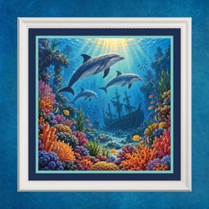 May include: A framed wall art print featuring three grey dolphins swimming in a vibrant coral reef. A sunken wooden ship rests in the background. The scene is filled with colourful orange, purple, and yellow coral formations and small tropical fish.