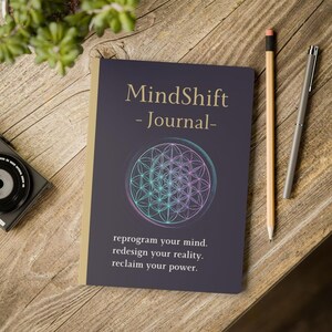 May include: A dark purple journal with a gold spine edge, featuring the text MindShift - Journal - above a geometric flower of life pattern and the text reprogram your mind. redesign your reality. reclaim your power. at the bottom of the cover.