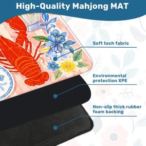 May include: A high-quality Mahjong mat with a colorful design featuring a red lobster, blue flowers, and a patterned background. The mat has a soft tech fabric surface, environmental protection XPE, and a non-slip thick rubber foam backing.
