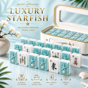 Könnte beinhalten: Ein Mahjong-Set mit hellblauen Spielsteinen, die geprägte Seestern- und Muschel-Motive aufweisen, wobei einige Steine rote und schwarze Schriftzeichen zeigen. Das Set enthält einen weißen Reisekoffer mit Reißverschluss und Sichtfenster.