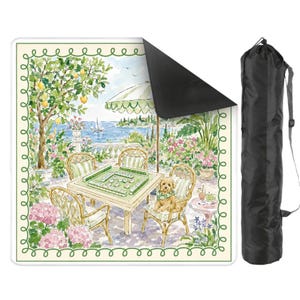 May include: A square mahjong mat with a scenic illustration of a patio overlooking a lake, with a table set for a game. The mat has a green border and comes with a black carrying case. The scene includes a dog, chairs, and an umbrella.