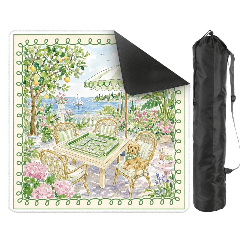May include: A square mahjong mat with a scenic illustration of a patio overlooking a lake, with a table set for a game. The mat has a green border and comes with a black carrying case. The scene includes a dog, chairs, and an umbrella.