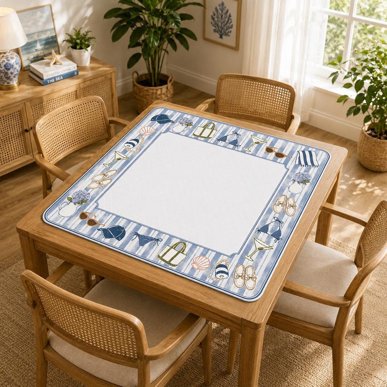 Puede incluir: Una mesa cuadrada de madera con cuatro sillas de mimbre. La mesa est&aacute; cubierta con un mantel individual a rayas blancas y azules. El mantel individual tiene un borde con ilustraciones de tem&aacute;tica playera, incluyendo conchas, gafas de sol y trajes de ba&ntilde;o.