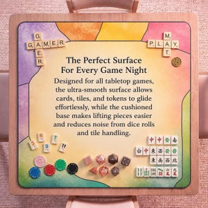 May include: A wooden-framed game night surface with colorful accents and the text "The Perfect Surface For Every Game Night." Includes game pieces, dice, and tiles. The surface is designed for tabletop games, with a smooth surface and cushioned base.