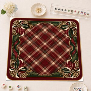 May include: A square mat featuring a central red, green, and beige plaid pattern framed by a dark green border. Each corner is decorated with a large bow in red, green, and gold, accented with a leopard print pattern and pine needle motifs.