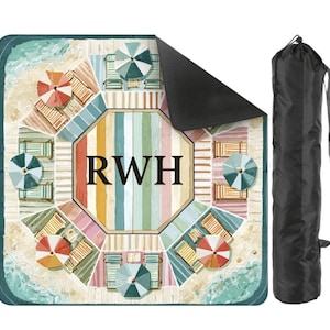 May include: A beach blanket with a colorful beach scene design, featuring beach umbrellas, lounge chairs, and the initials "RWH" in the center. Includes a black carrying bag with a shoulder strap. The blanket is square-shaped.