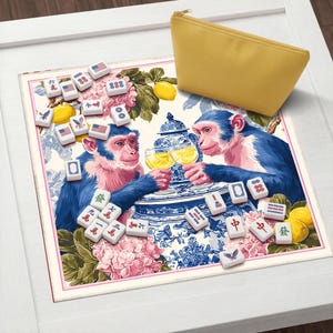 Pu&ograve; includere: Un tappetino decorativo con un design stravagante con due scimmie blu che brindano con bicchieri di liquido giallo. Il tappetino include un vaso di porcellana blu e bianco, limoni e tessere di Mahjong. Un astuccio giallo con cerniera &egrave; nell'angolo in alto a destra.