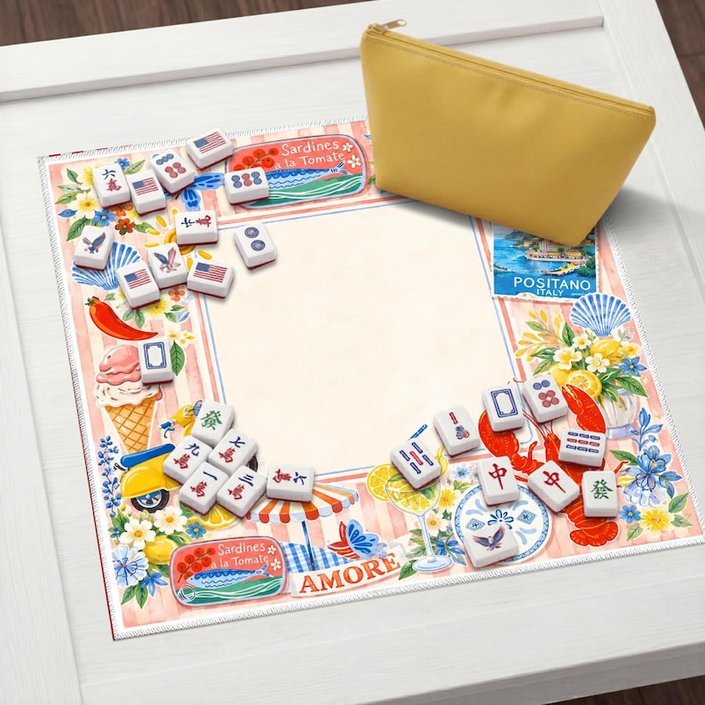 May include: A yellow zippered pouch rests on a decorative Mahjong game mat. The mat features a border with Italian imagery, food illustrations, and Mahjong tiles. The game tiles are white with black symbols and red accents.