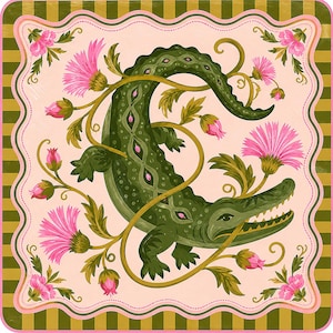 May include: A square decorative print featuring a central dark green alligator surrounded by pink thistle flowers and winding vines. The design is set against a light pink background with a scalloped border and an outer frame of olive green stripes.