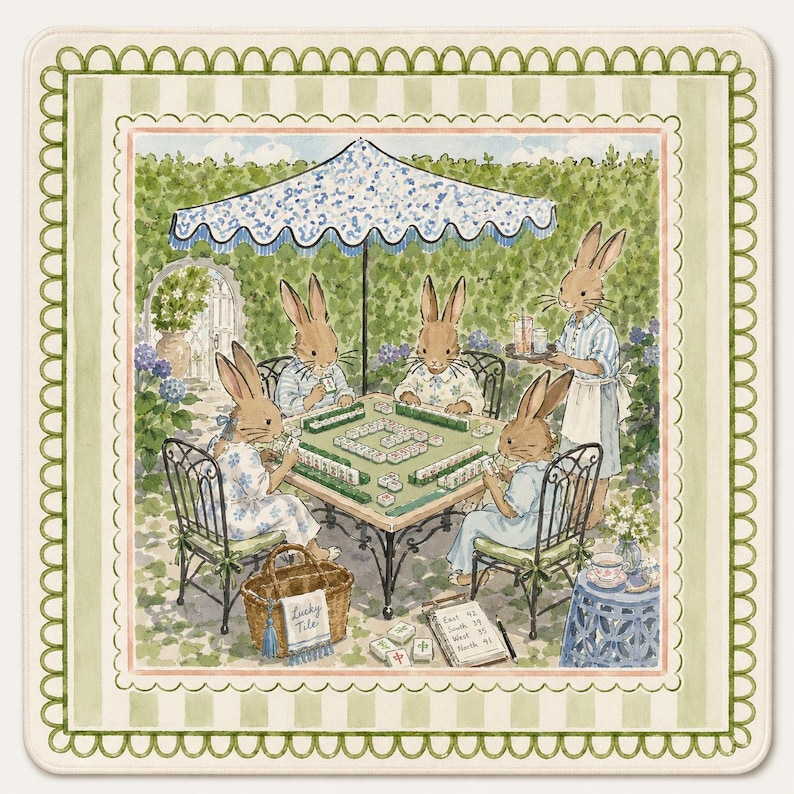 May include: A square decorative mat featuring a watercolor illustration of four rabbits playing mahjong at a table under a blue and white umbrella in a garden. A fifth rabbit serves drinks. A basket labeled Lucky Tile and a score pad are visible.