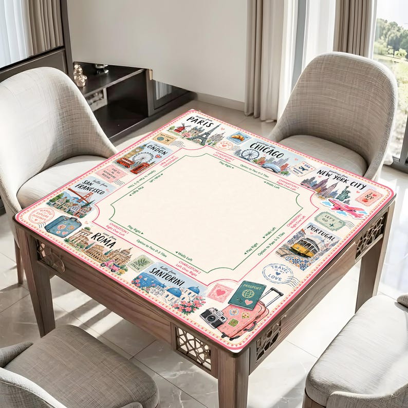 May include: A square wooden table with a travel-themed game board surface. The board features illustrations of famous cities like Paris, London, and New York City. The border is pink with travel-related icons, and the center is a light beige color.