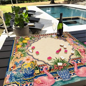 Pode incluir: Um tabuleiro de jogo decorativo com um design vintage com um flamingo, uma garrafa de champanhe e uma ta&ccedil;a de champanhe. O tabuleiro est&aacute; colocado numa mesa escura perto de uma piscina. As pe&ccedil;as do jogo s&atilde;o rosa e brancas.