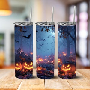 May include: Three Halloween-themed tumblers with a spooky forest scene. The design features glowing jack-o'-lanterns, bats, and a misty forest background. Each tumbler has a silver lid and a clear straw, perfect for seasonal beverages.