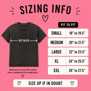 May include: A black t-shirt with sizing information. The text "SIZING INFO" is at the top. Measurements are provided for sizes Small to XXL, ranging from 18" to 27.5" pit to pit. The text "SIZE UP IF IN DOUBT" is at the bottom.