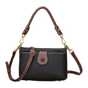 May include: Black leather crossbody bag with brown accents. Features a brown top handle and a detachable shoulder strap. The bag has a flap closure with a brown button and gold-tone hardware. White stitching details the edges.