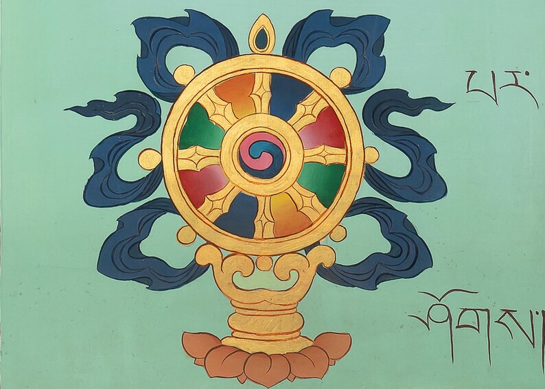 May include: A hand-painted Dharma Wheel, a Buddhist symbol, in vibrant colours. The wheel has red, green, yellow, and blue segments, with a central swirl. Dark blue ribbons and gold detailing are also present.