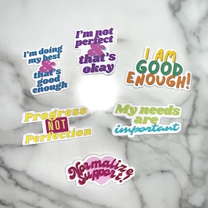Può includere: Una collezione di adesivi colorati con frasi motivazionali. Gli adesivi presentano frasi come "Sto facendo del mio meglio", "Sono abbastanza bravo" e "Progresso, NON perfezione". Gli adesivi hanno un bordo bianco e sono di vari colori.