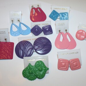 May include: Assortment of colorful earrings in various shapes and sizes, including geometric, floral, and abstract designs. The earrings are displayed on white cards with the text "Fashion Earrings".