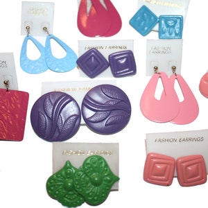 May include: Assortment of colorful plastic earrings in various shapes and designs, including geometric, floral, and abstract patterns. The earrings are displayed on white cards with the text "Fashion Earrings".