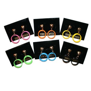 May include: Assortment of eight pairs of heart-shaped dangle earrings with colorful circular hoops. The hoops are in pink, orange, yellow, blue, green, and black.