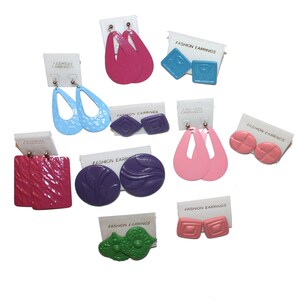 May include: Assortment of colorful plastic earrings in various shapes and designs, including teardrop, square, and round. The earrings are packaged on small cards with the text "Fashion Earrings".