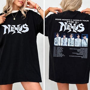 May include: A black t-shirt featuring the word NEXUS in white stylized lettering on the front. The back displays 2026 MONSTA X WORLD TOUR THE X: NEXUS text, a photograph of five individuals in white suits, and a list of tour dates and locations.