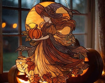 May include: Stained glass Halloween decoration featuring a witch holding a pumpkin, with a large orange moon in the background. The witch is wearing a hat and dress in shades of brown and orange. Two carved pumpkins with lit faces are in the foreground.
