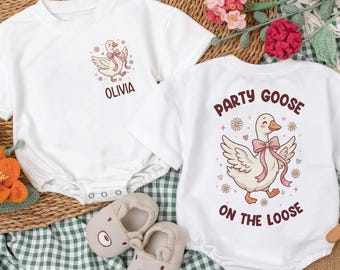 May include: Two white baby onesies with goose graphics. One says "Olivia" and the other says "Party Goose on the Loose." The image includes a pair of beige baby shoes and decorative flowers.
