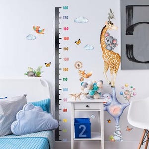 May include: A white ceramic mug with a black handle and the text "But First, Coffee" in a black, handwritten-style font. The mug is on a white surface.