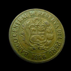 Puede incluir: Primer plano de una moneda de bronce con el texto "BANCO CENTRAL DE RESERVA DEL PERU" y el año "1976". La moneda presenta un escudo de armas con un ciervo, un árbol y una cornucopia.