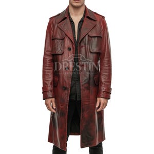 May include: A long, burgundy leather trench coat with a distressed finish. The coat features a double-breasted closure, notched lapels, and a belt detail at the cuffs. The brand name "DRESTIN LEATHER FASHION" is printed on the coat.