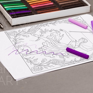May include: A white paper with a black line drawing of a figure with a bow and arrow, surrounded by floral elements. Three purple pastels and a box of colorful pastels are on the gray surface. A black pen and eraser are also present.