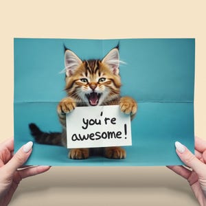 Wertschätzung Nachricht. Kätzchen mit lesender Karte "" you're amesome "" . Fröhlicher Ausdruck. Positiv zu erkennen. Sofortiger Download, bearbeiten und drucken.