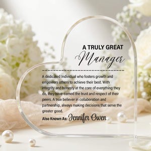 May include: A clear, heart-shaped acrylic plaque featuring black printed text that reads A TRULY GREAT Manager, followed by a paragraph describing a dedicated individual, and the name Jennifer Owen at the bottom.