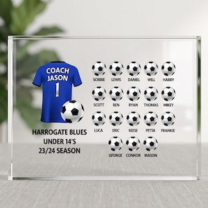 May include: A clear acrylic block displays a blue football shirt with "COACH JASON" and the number 1. Footballs and player names are arranged around the shirt, with the text "HARROGATE BLUES UNDER 14'S 23/24 SEASON".