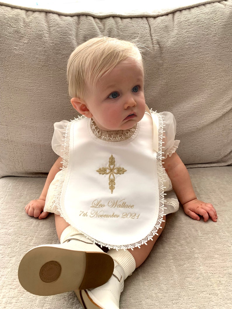Baptism bib in white or cream with a cross of your choice from www.lyubove.co.uk Lyubove Christenings