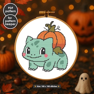 Op de afbeelding: Kruissteekpatroon van een groen stripfiguur met een pompoen op de rug, in een houten borduurring. De tekst luidt "PDF pattern" en "for pattern keeper". De afmeting is 100 x 100 steken.