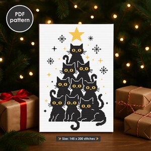 Pode incluir: Um padrão de ponto cruz com um design de árvore de Natal feito de gatos pretos com olhos amarelos e uma estrela no topo. A obra de arte inclui flocos de neve e estrelas em um fundo branco. O texto "PDF pattern" está em um círculo. O tamanho é de 145 x 200 pontos.