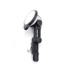 May include: A dark gray adjustable mounting arm featuring a circular magnetic charging pad at the top. The device includes two rotating joints with circular knobs for positioning and a white USB-C charging cable attached to the side.